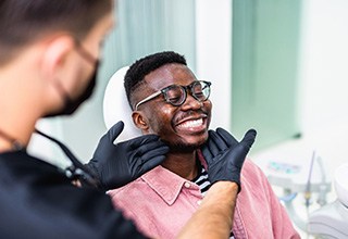 Dentist looking at patient's smile in treatment room
