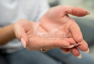 Closeup of patient holding clear aligner