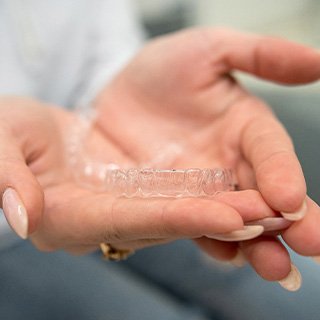 Closeup of patient holding clear aligner