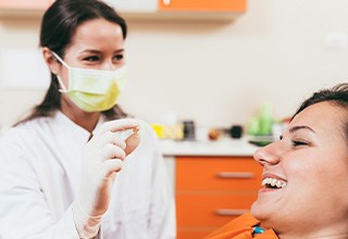 A dentist showing a female patient her extracted tooth