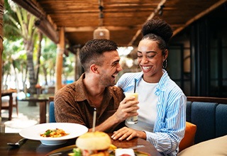 Couple smiling while enjoying meal at restaurant
