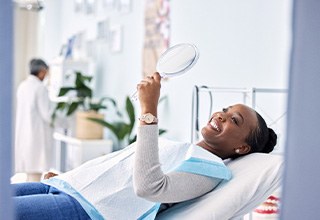 Woman smiling while looking at reflection in mirror
