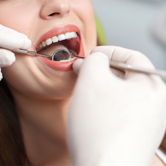 A woman having her teeth examined at the dental office