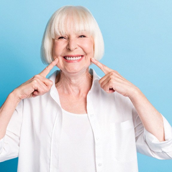 Woman pointing to her smile