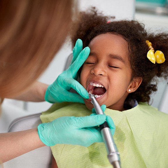 Young girl receiving dental checkup and teeth cleaning