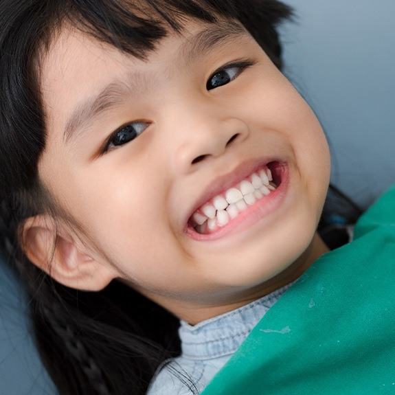 Child smiling after fluoride treatment