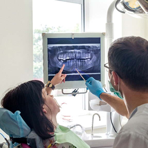 a dentist showing a patient how their teeth are moving