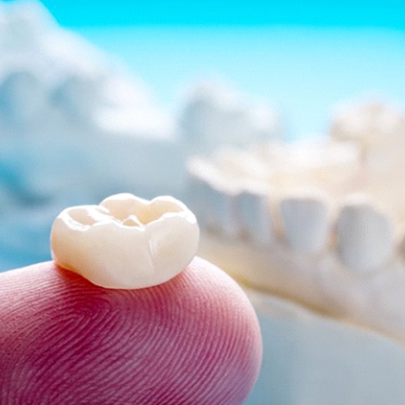 dentist in Weatherford holding a dental crown on their finger