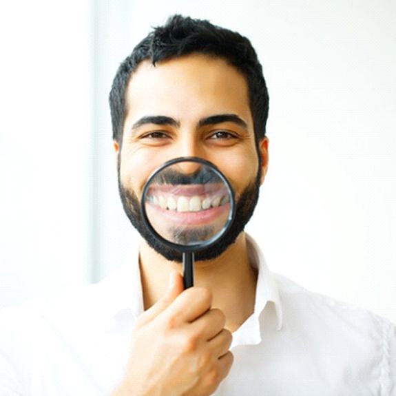 man showing off his pearly whites with a magnifying glass