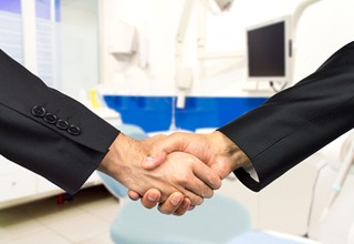 Dentist and patient shaking hands after an appointment