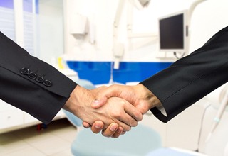 Dentist and patient shaking hands after an appointment