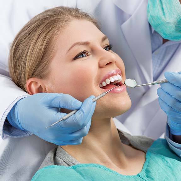 Woman preventing dental emergencies in Weatherford by completing dental exam