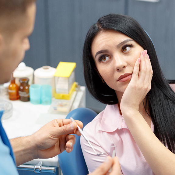 woman with toothache looking at dentist 