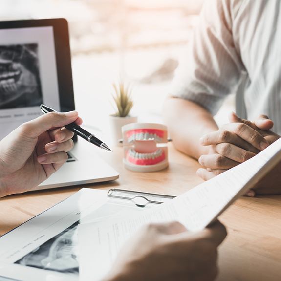 Dentist and patient reviewing dental insurance forms