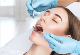 Woman at dentist’s office receiving an examination