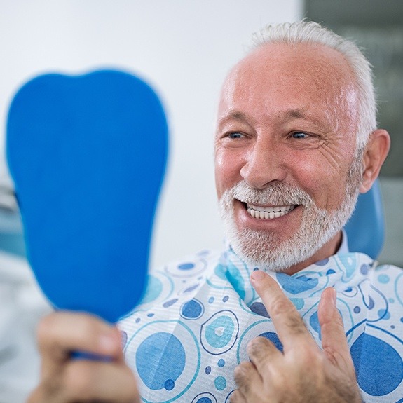 Man with denture looking at his new smile
