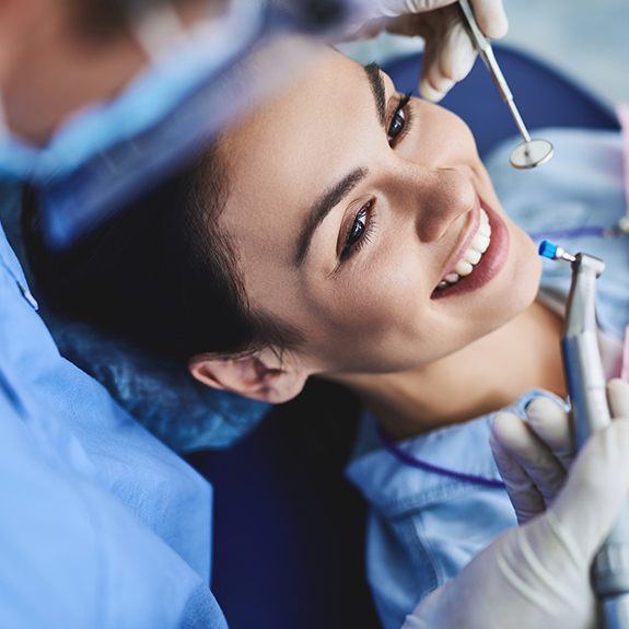 Woman smiling during dental checkup and teeth cleaning visit