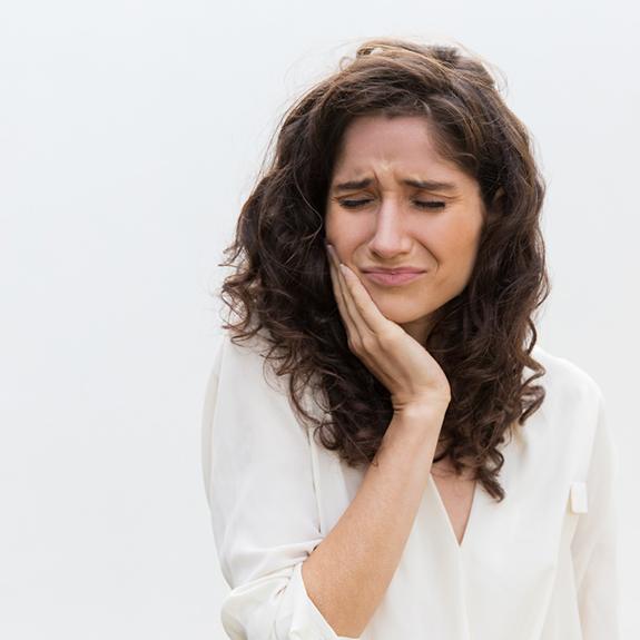 Woman with toothache who may need root canal therapy