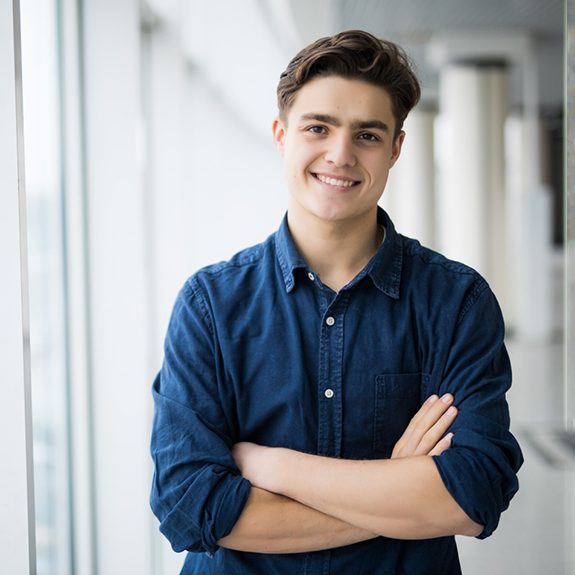 Confident, smiling young man with arms crossed