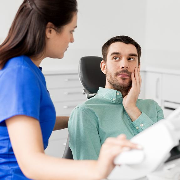 Dental team member talking to patient about root canal therapy