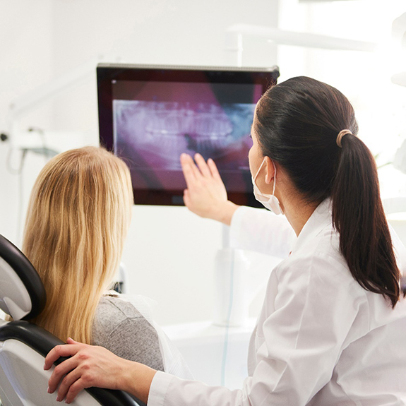 Dentist reviewing dental X-ray with patient during appointment