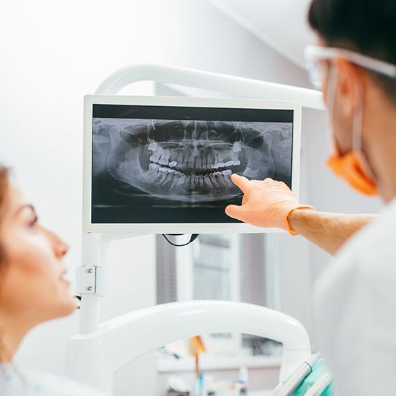 Dentist and patient looking at digital dental x-rays