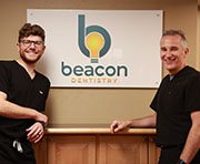 Weatherford dentists posing next to Beacon Dentistry of Weatherford sign