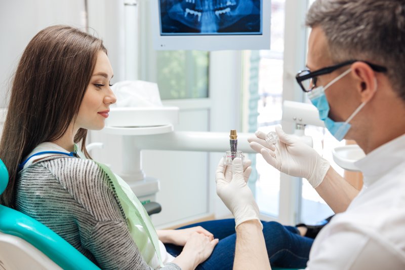 Dentist explaining the basics of dental implants to a patient