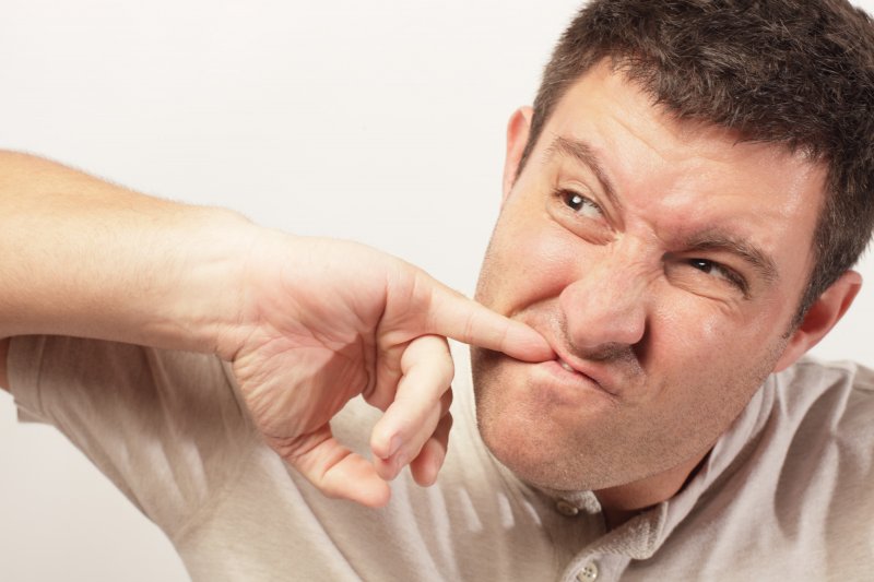 A man with an object stuck between teeth