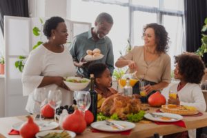 family standing around Thanksgiving food together