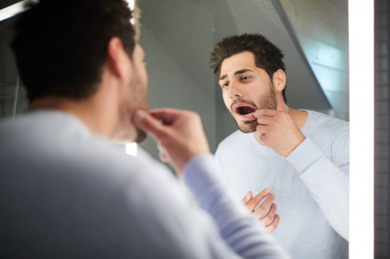 Man checking his teeth to see if he needs a root canal