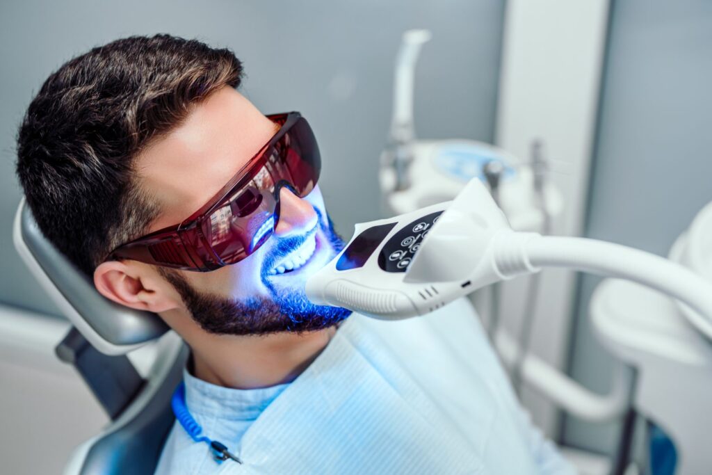 A man getting professional teeth whitening from his dentist
