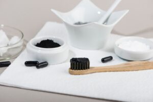 Charcoal and other teeth whitening instruments laying on counter.